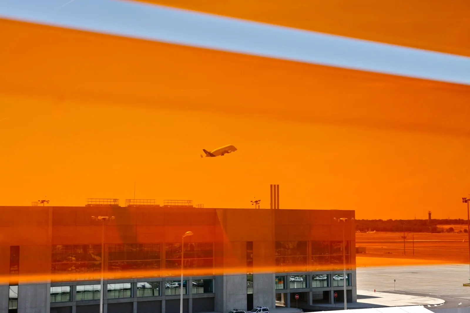 Décollage vu depuis un niveau du parking, à travers le bardage orange de l’ouvrage