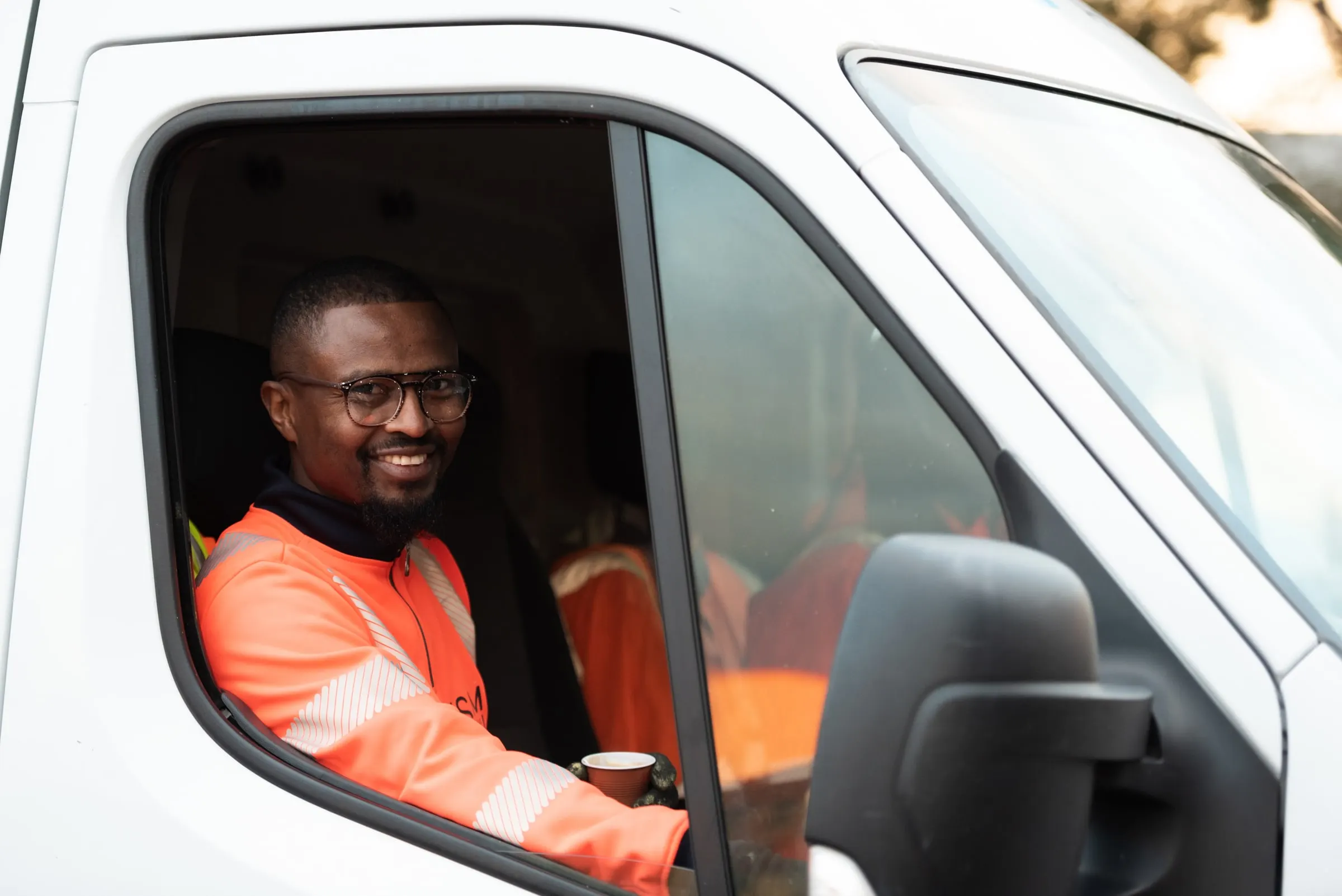 Chauffeur ASM souriant au volant d’un fourgon