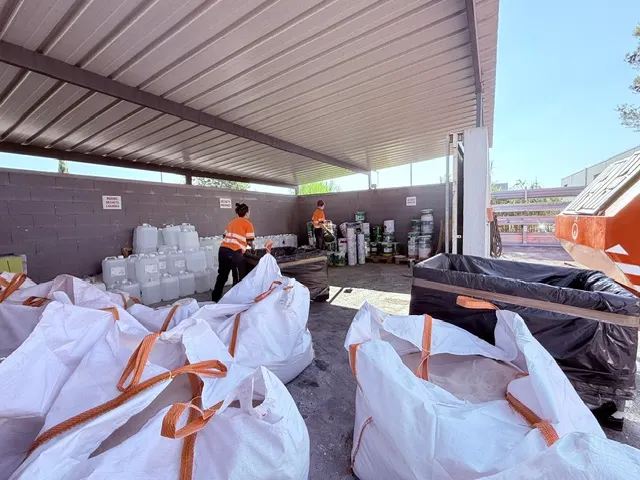 Le point de collecte des déchets au dépôt ASM : bidons, big bags et fûts triés sous un auvent, deux salariés au travail