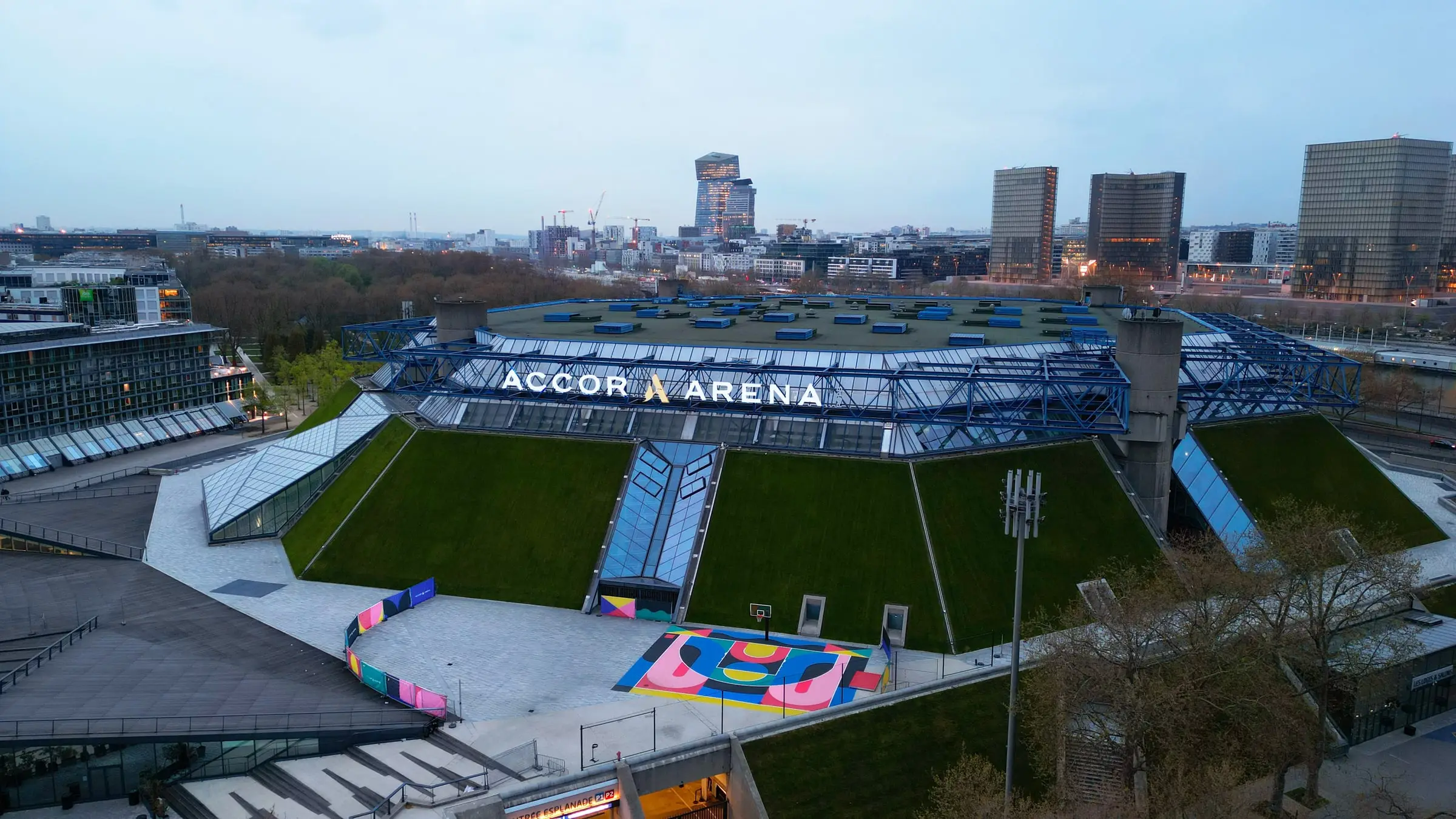 Vue aérienne de l’Accor Arena et de ses terrains sportifs colorés sur le parvis