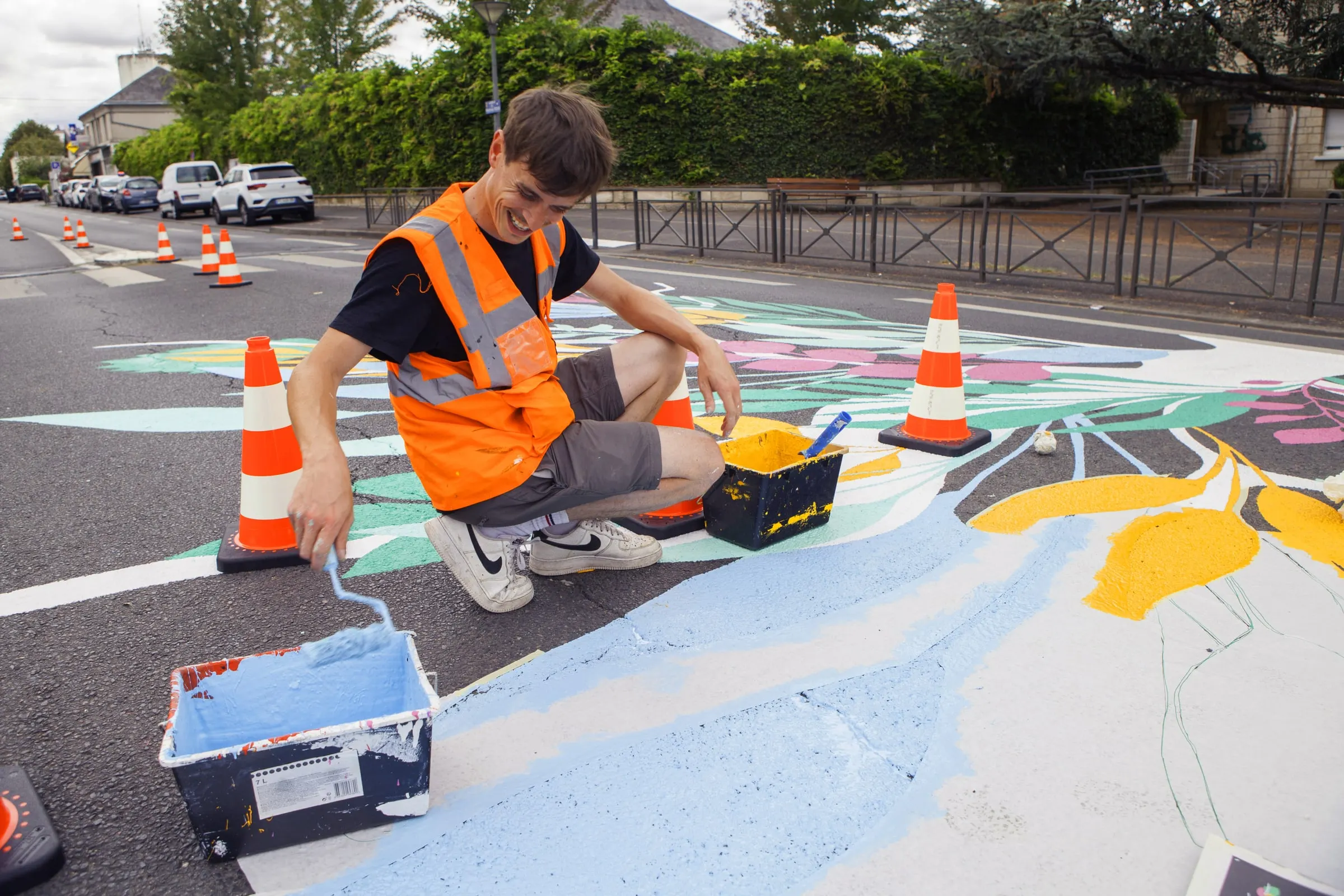 Artiste ASM agenouillé peignant une fresque au sol
