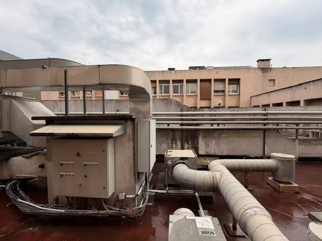 Réseaux et gaines de ventilation bruts sur une toiture technique, avant intervention