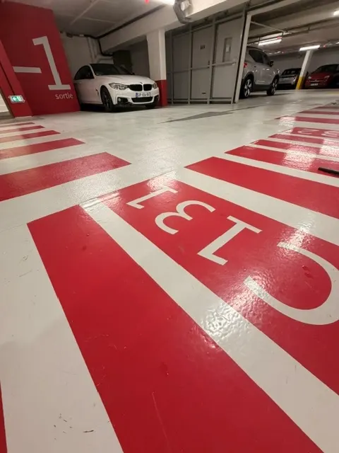 Numérotation au sol d’une place du parking du Diamant, repère de niveau peint sur la paroi
