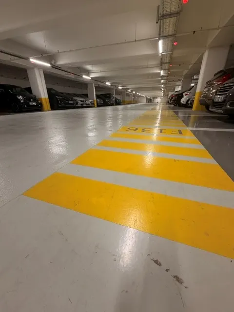 Allée du parking du Diamant en résine, cheminement piéton jaune sur fond gris clair