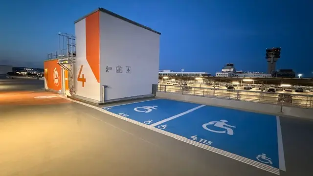 Places PMR bleues en toiture de parking, au crépuscule
