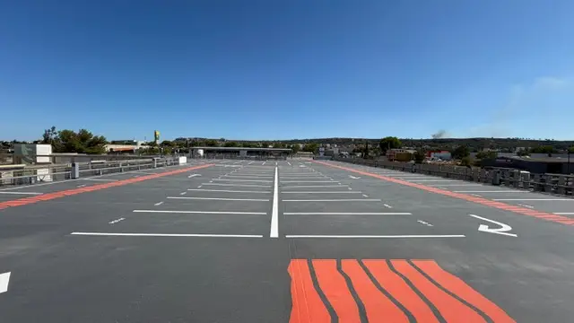 Niveau en toiture du parc relais Cap Horizon, places blanches et zébras rouges tracés sur enrobé neuf