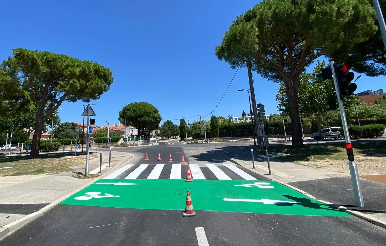Piste cyclable traitée en revêtement vert avec pictogramme vélo peint au sol