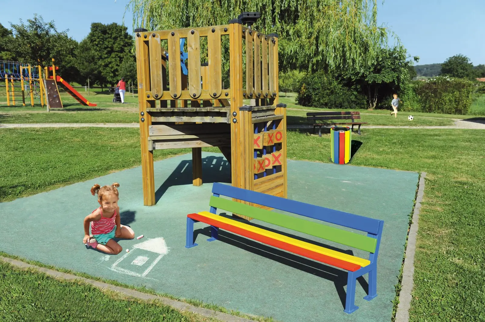 Banc coloré installé au bord d’une aire de jeux au sol souple
