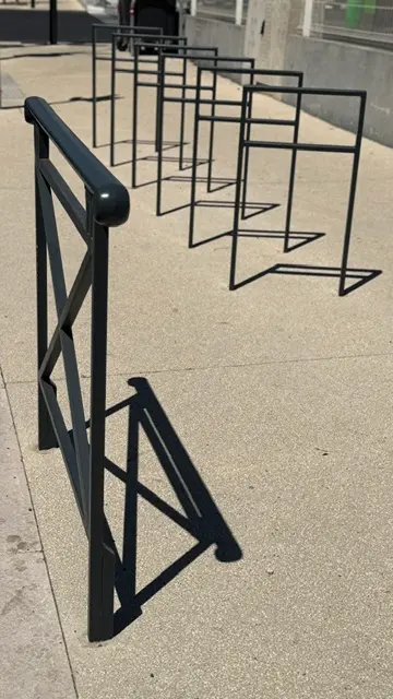 Arceaux vélos noirs alignés le long d’un cheminement