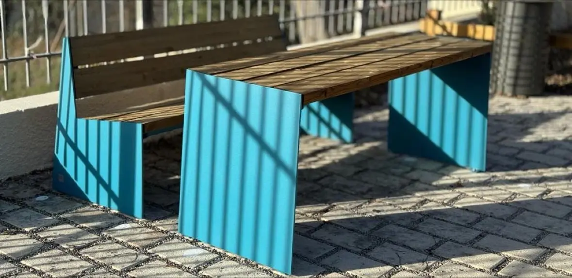 Bancs à flancs colorés et assise bois posés sur un parvis pavé