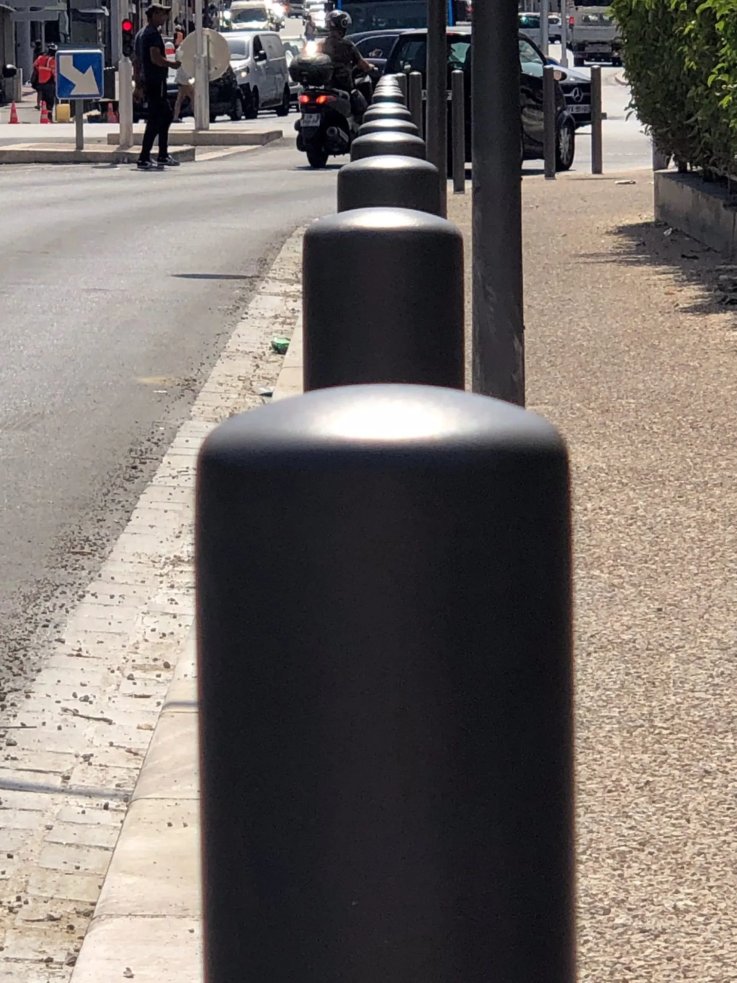 Gros plan d’une borne de protection noire posée en bord de trottoir