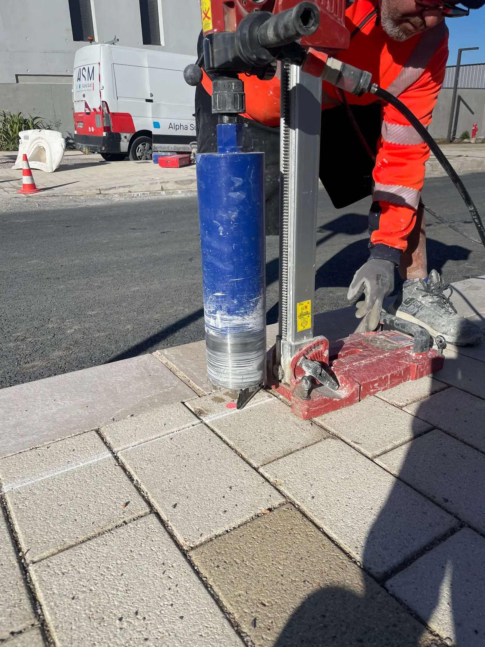 Carotteuse en action sur un pavage, avant scellement d’un potelet