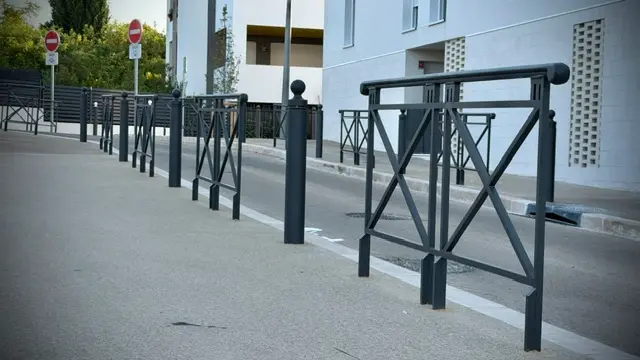 Garde-corps et potelets alignés sur un cheminement piéton
