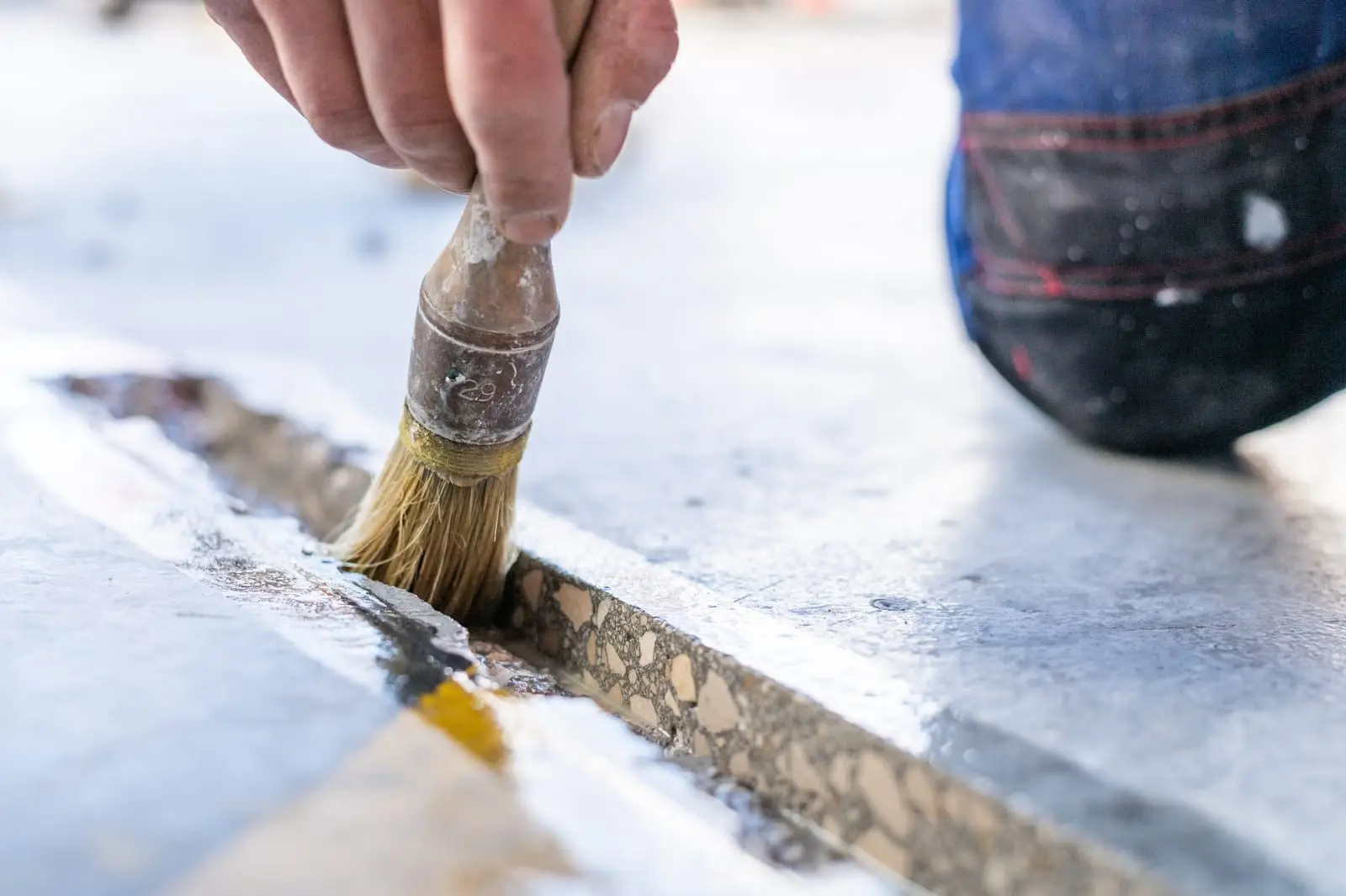 Brossage à la main d’un joint de dallage avant rebouchage