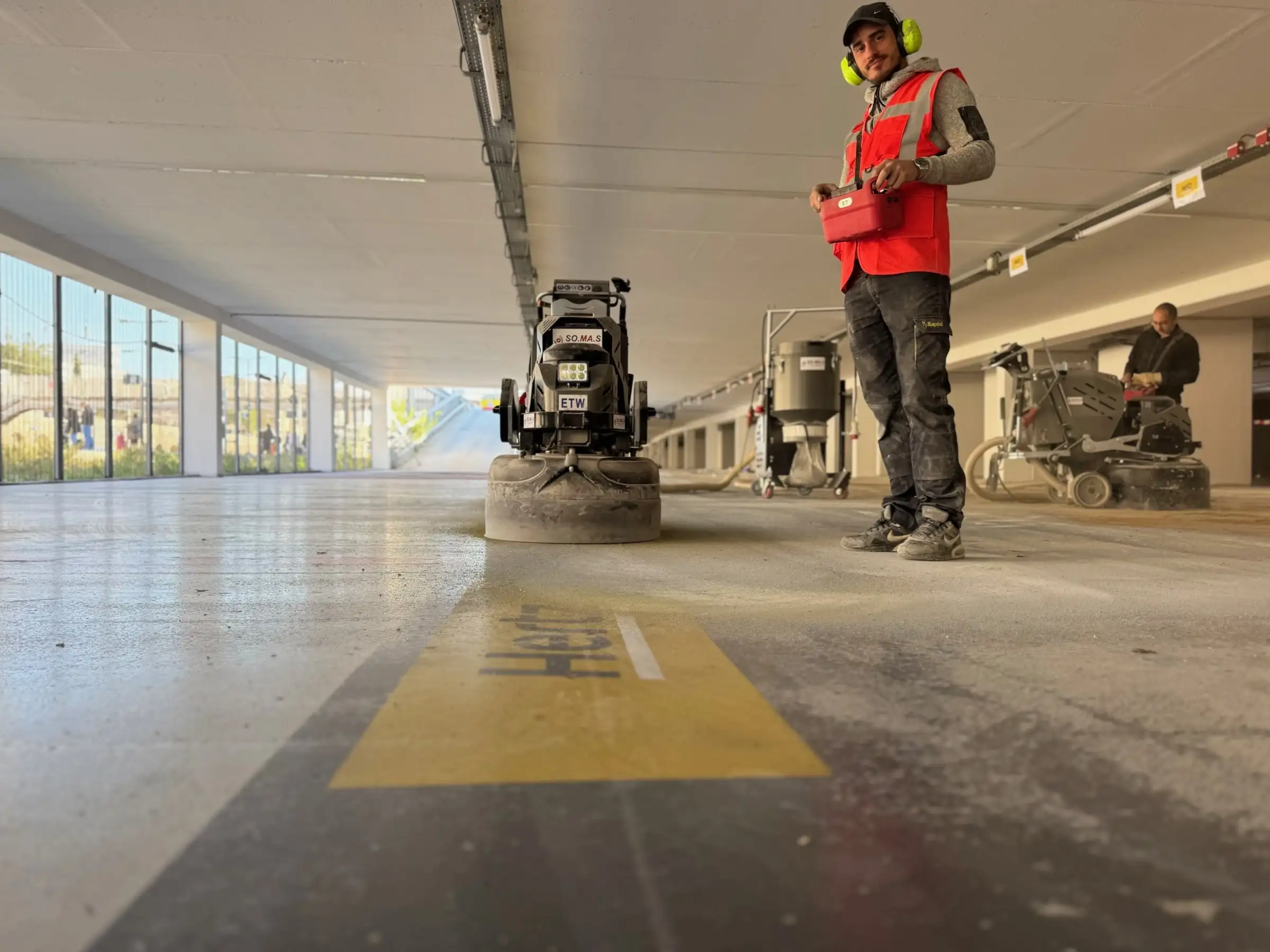 Surfaçage mécanique d’un sol de parking en cours de préparation