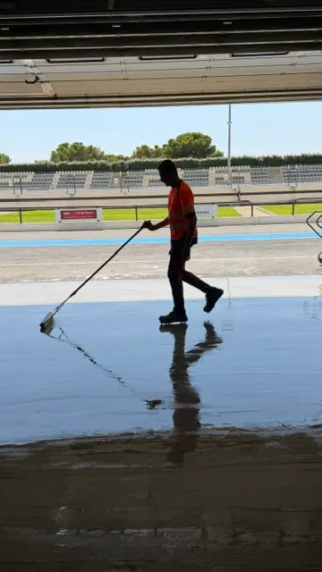 Applicateur ASM étalant la résine à la raclette sur une grande surface