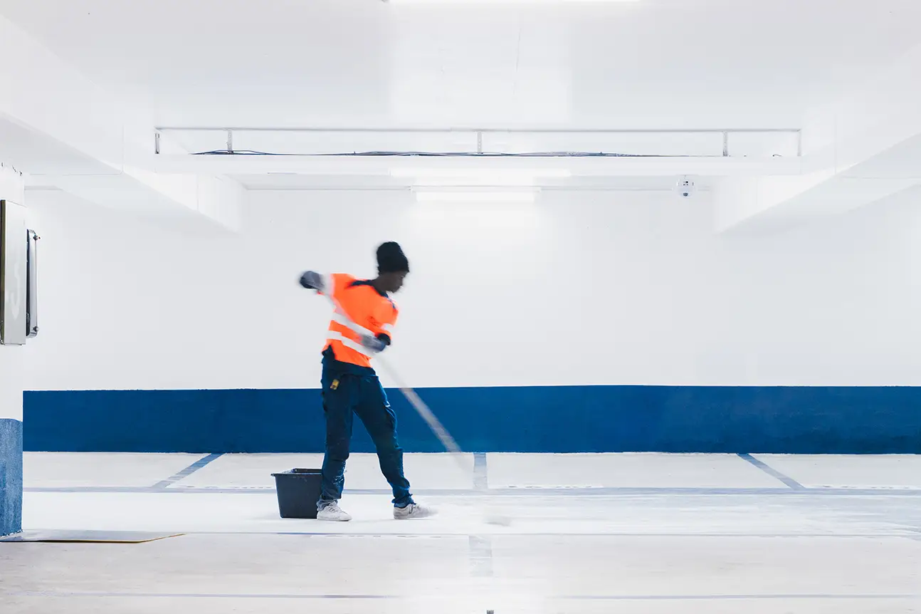 Application d’une résine de sol au rouleau sur un niveau de parking en travaux