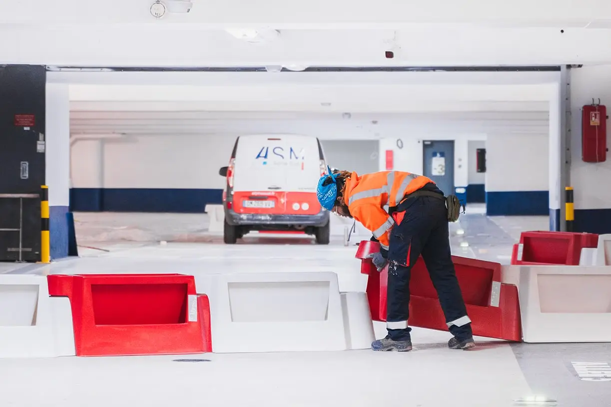 Matériel installé sur un plateau de parking en cours de mise en résine, fourgon ASM au fond