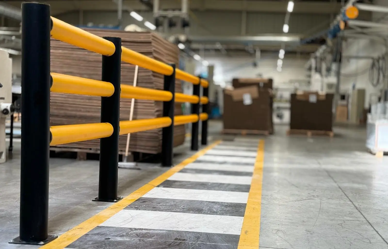 Barrière de protection jaune posée le long d’une allée d’entrepôt