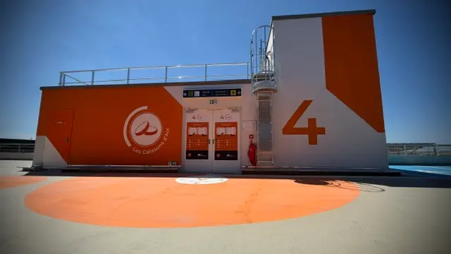 Noyau de circulation traité aux couleurs du niveau, en toiture de parking