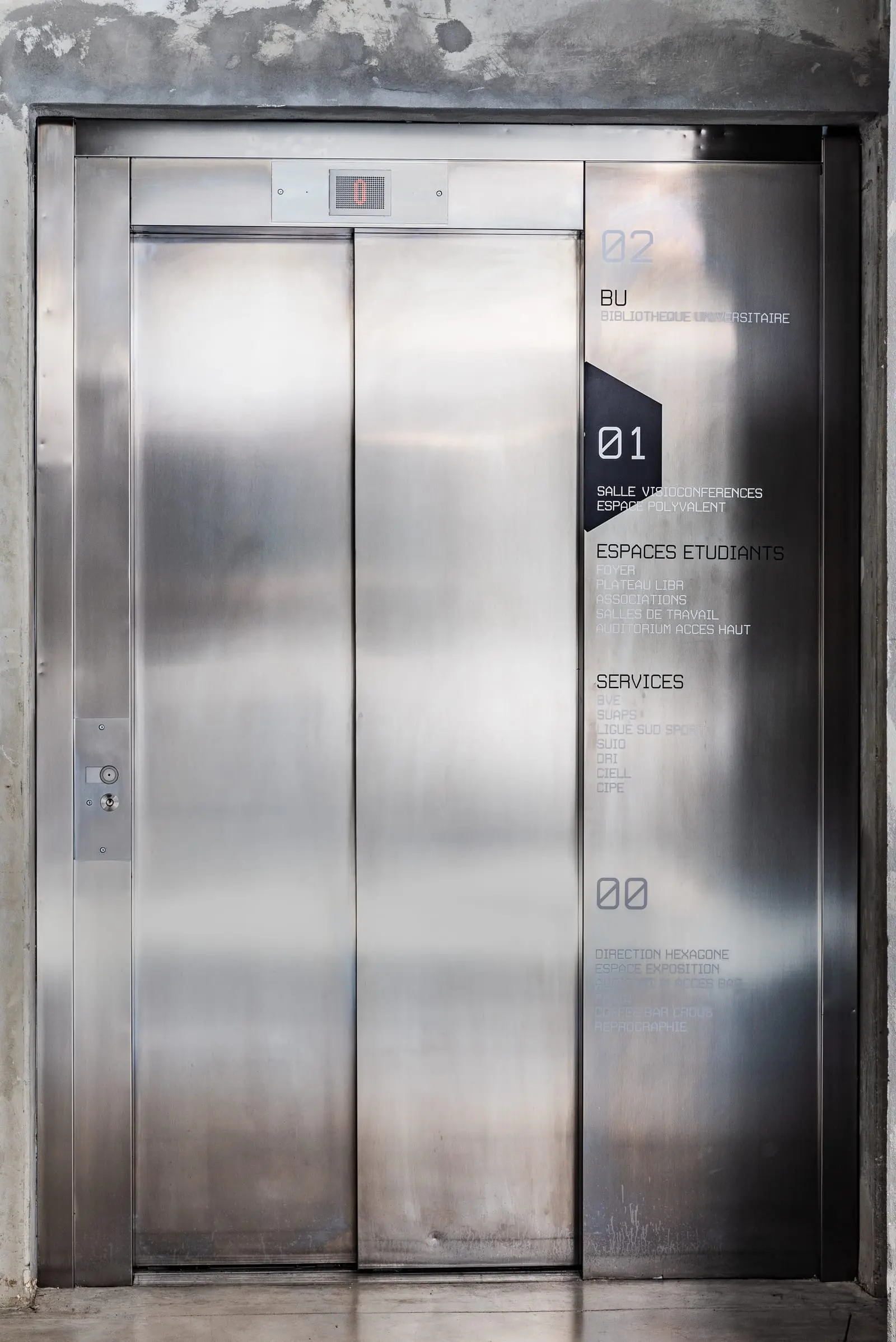 Signalétique de palier appliquée sur les portes inox d’un ascenseur