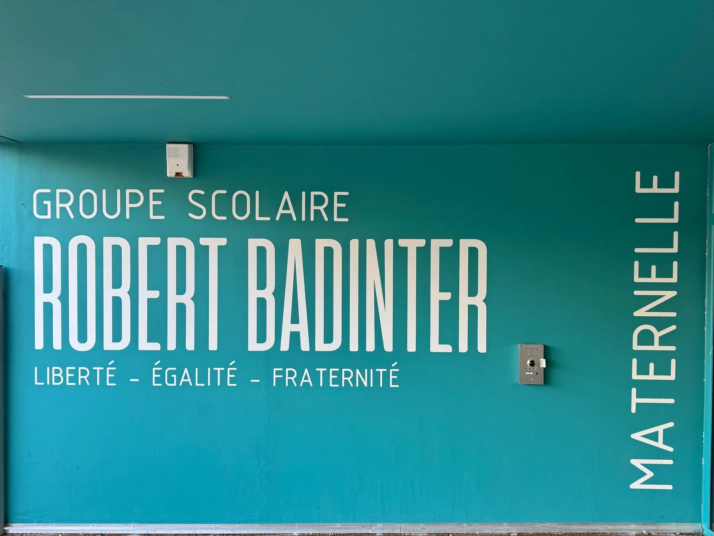 Signalétique murale grand format d’un groupe scolaire, lettrage blanc sur fond coloré