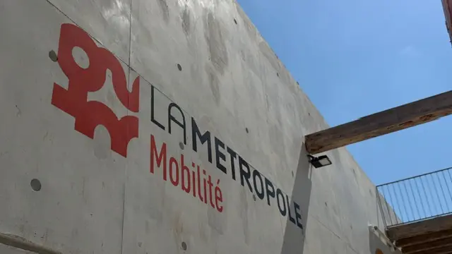 Lettrage du réseau de mobilité appliqué sur un mur béton de parc relais