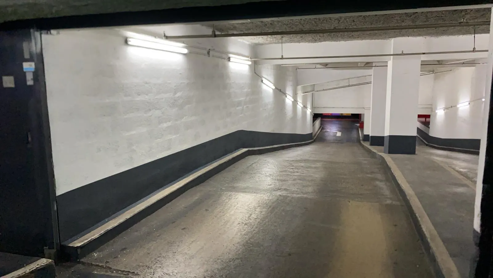 Rampe d’accès du parking Centre Bourse, parois claires et soubassement sombre
