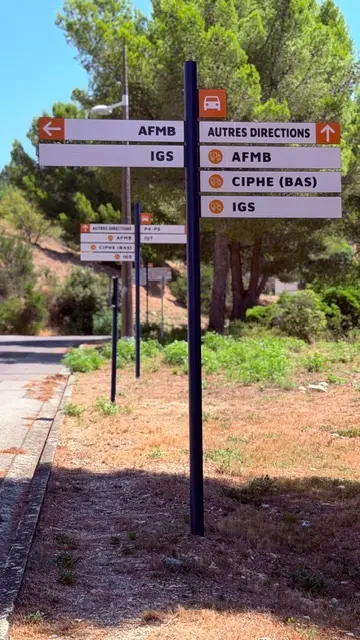 Mât directionnel jalonnant les laboratoires d’un campus universitaire