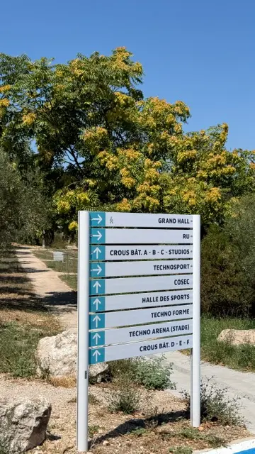 Jalonnement piéton d’un campus, lames de destination empilées sur un mât