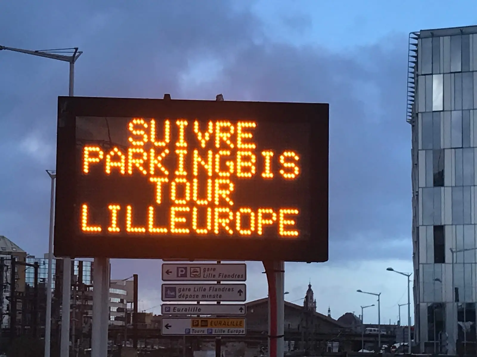Panneau à messages variables orientant vers un parking, de nuit