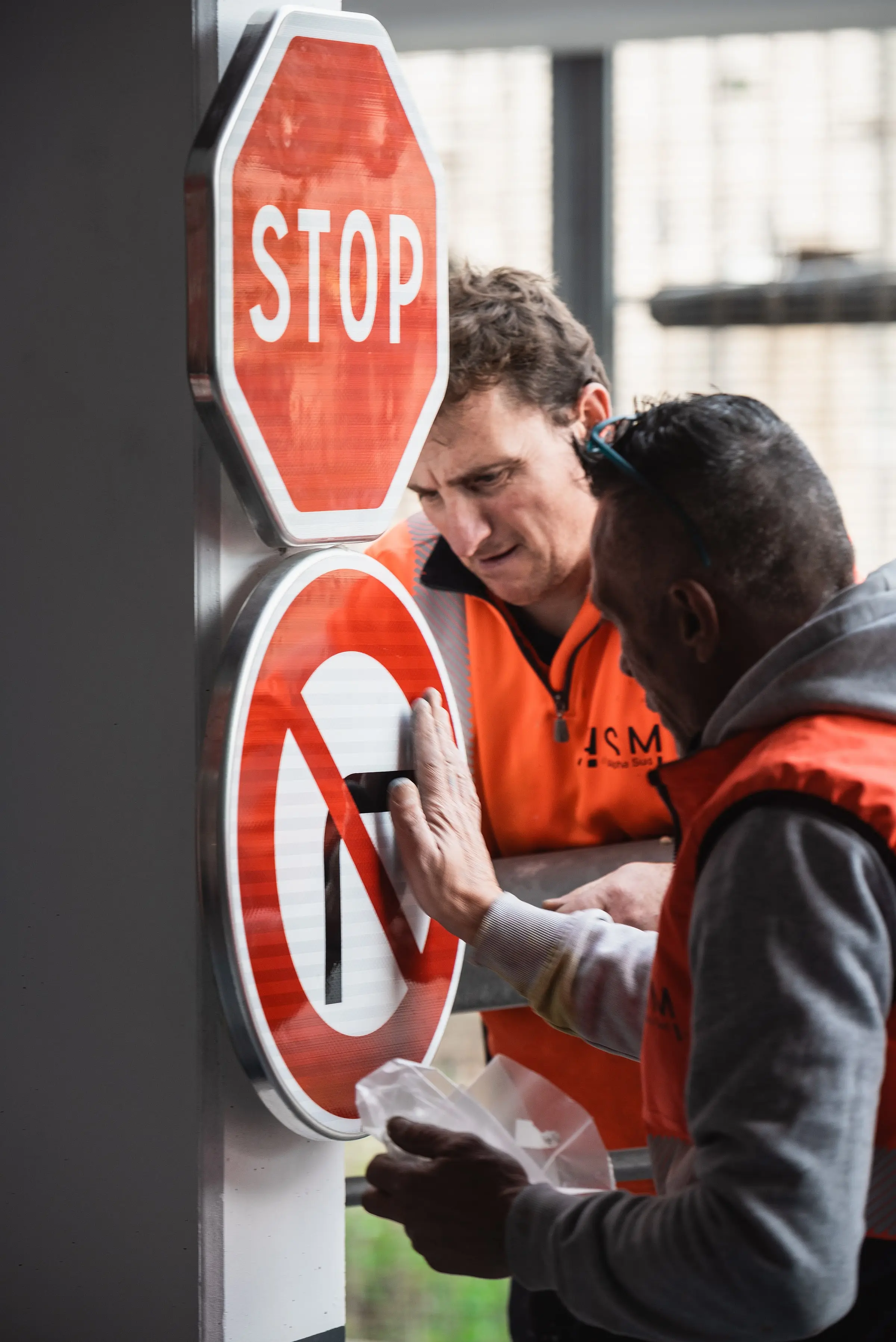 Poseur ASM installant un panneau de signalisation