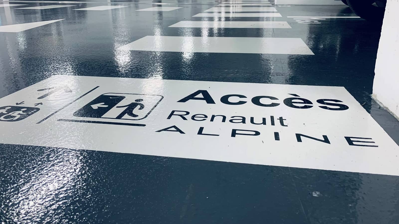 Sol résine de parking avec marquage directionnel et pictogramme d'accès peint au sol