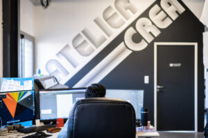 Graphiste travaillant dans l’atelier de création graphique ASM sur deux écrans
