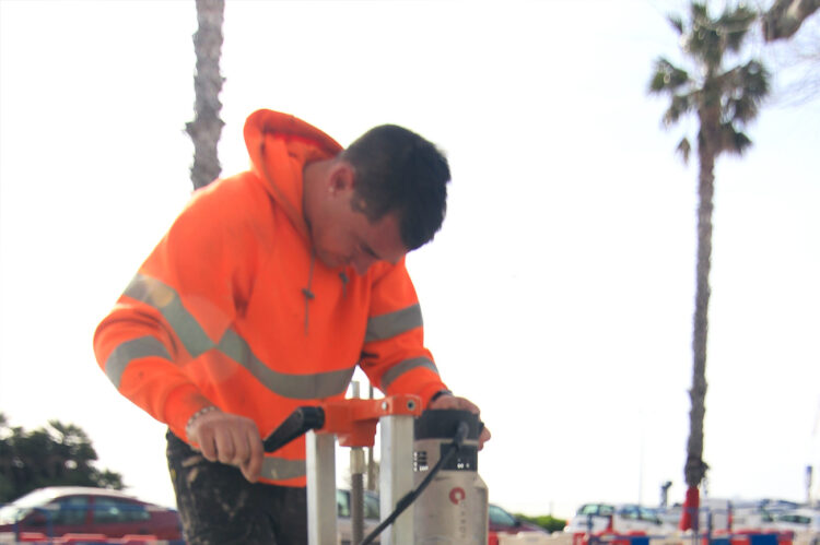 Technicien ASM utilisant une carotteuse pour percer le sol lors d’un chantier de préparation.