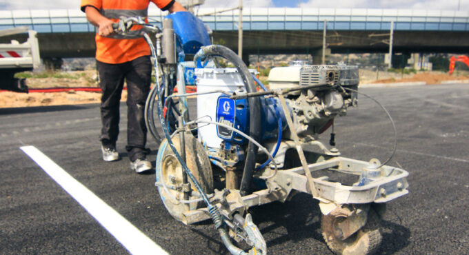 Marquage au sol de bandes de parking blanches réalisé avec une machine traceuse professionnelle.