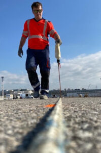 Opérateur réalisant un prémarquage au sol avant la pose définitive de la signalisation horizontale.