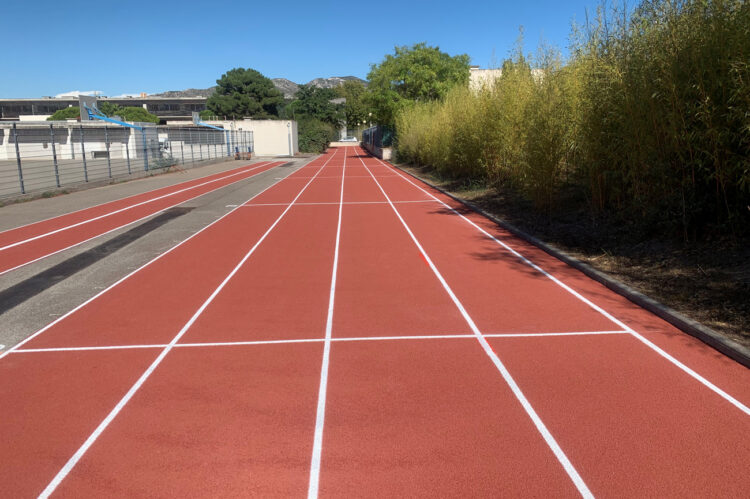 Piste d’athlétisme en résine EPDM rouge, revêtement sportif résistant et antidérapant.
