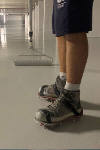 Application d’une résine polyuréthane auto-lissante sur sol industriel.