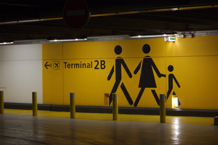 Signalétique artistique murale avec silhouette jaune et cheminement piéton au sol.