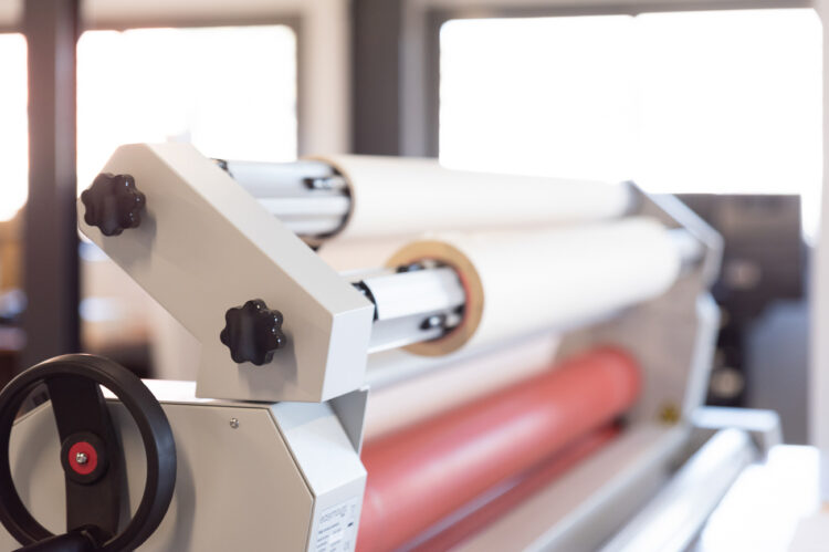 Table de lamination professionnelle dans l’atelier ASM, utilisée pour la pose de vinyles et adhésifs de signalétique.