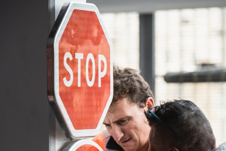 Techniciens ASM installant un panneau de signalisation verticale de type Police STOP et interdiction de tourner.